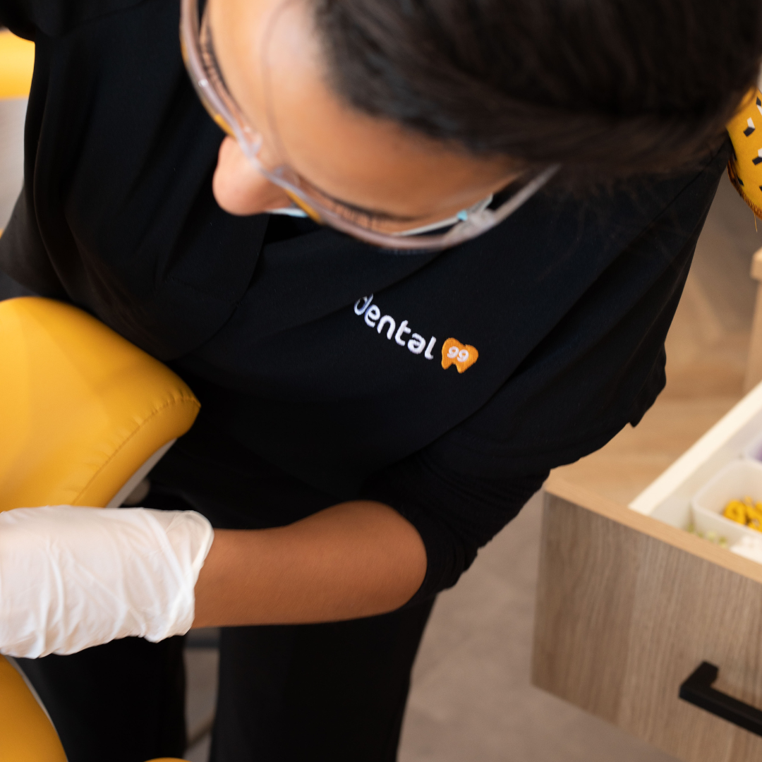 Dentist from Dental99 in Australia performing a dental procedure on a patient in the clinic, showing treatment in progress.